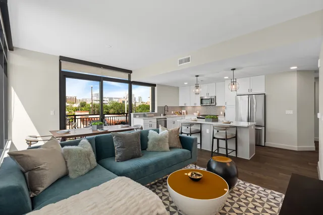 a living room with furniture and a view of kitchen