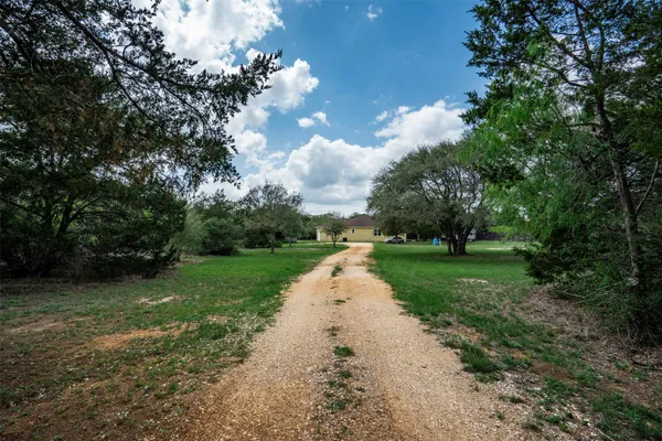 a view of a street with a yard and lake view