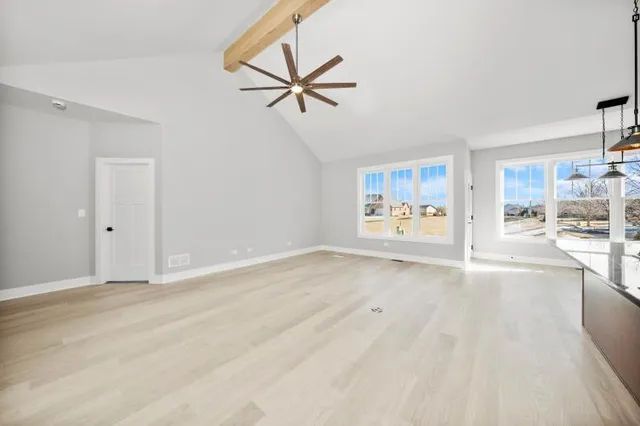 a view of empty room with wooden floor and window