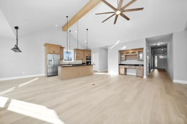 a view of empty room with kitchen appliances and a ceiling fan