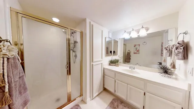 a bathroom with a double vanity sink mirror and shower