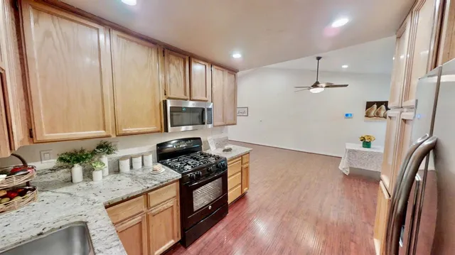 a kitchen with stainless steel appliances a refrigerator and wooden floor