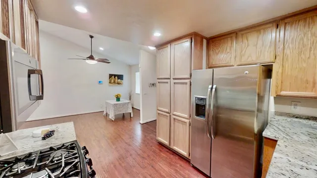 a kitchen with granite countertop wooden cabinets and a stove top oven