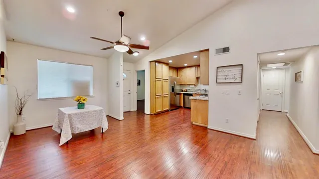 a kitchen with stainless steel appliances granite countertop a refrigerator a stove and a wooden floor