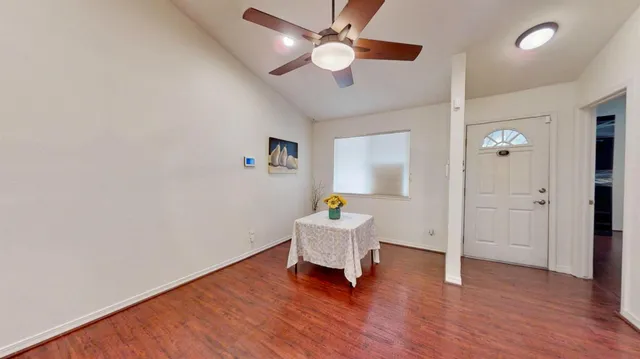 a view of a hallway with wooden floor and a chandelier