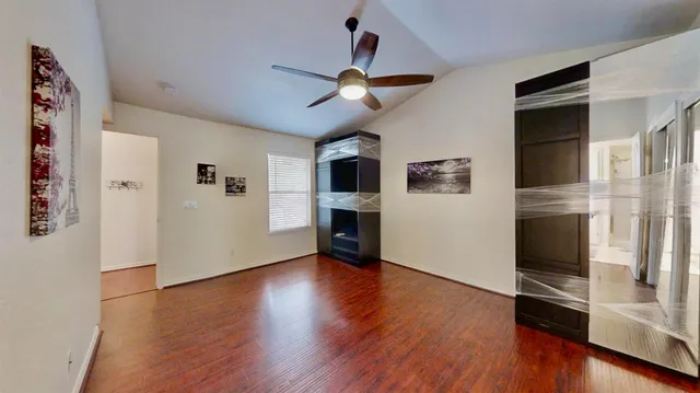a view of a livingroom with wooden floor and a ceiling fan