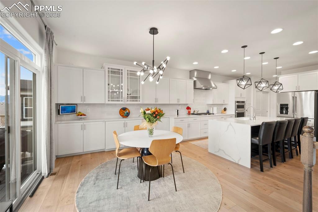 4661 Horse Gulch Loop Colorado Springs, CO 80924 - Photo 11 of 48 a kitchen with a dining table chairs appliances and cabinets