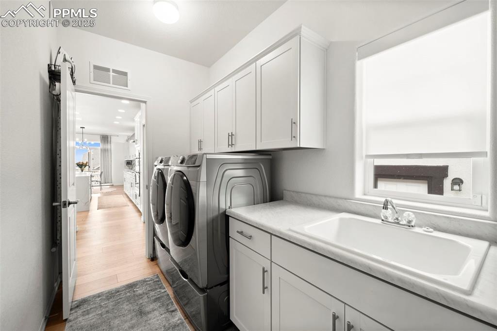 4661 Horse Gulch Loop Colorado Springs, CO 80924 - Photo 16 of 48 a utility room with cabinets washer and dryer