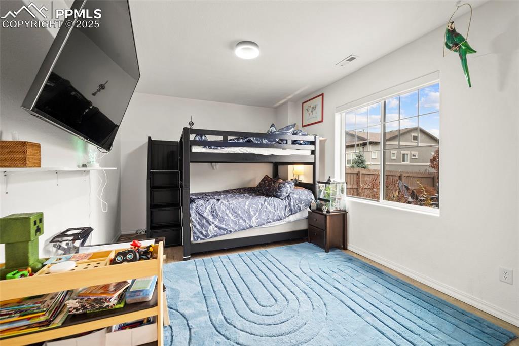 4661 Horse Gulch Loop Colorado Springs, CO 80924 - Photo 26 of 48 a bedroom with a bed and a flat tv screen on the dresser