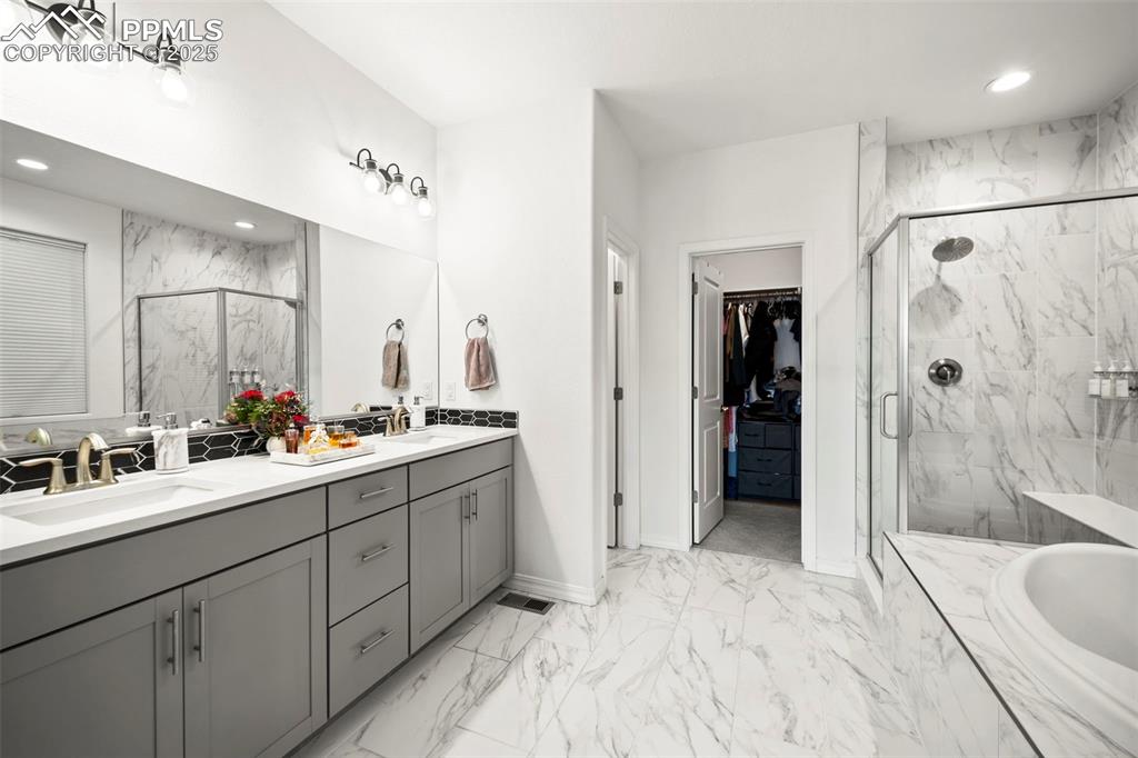 4661 Horse Gulch Loop Colorado Springs, CO 80924 - Photo 34 of 48 a bathroom with a double vanity sink mirror and shower