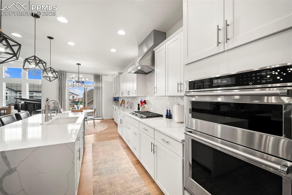 4661 Horse Gulch Loop Colorado Springs, CO 80924 - Photo 10 of 48 a large white kitchen with stainless steel appliances