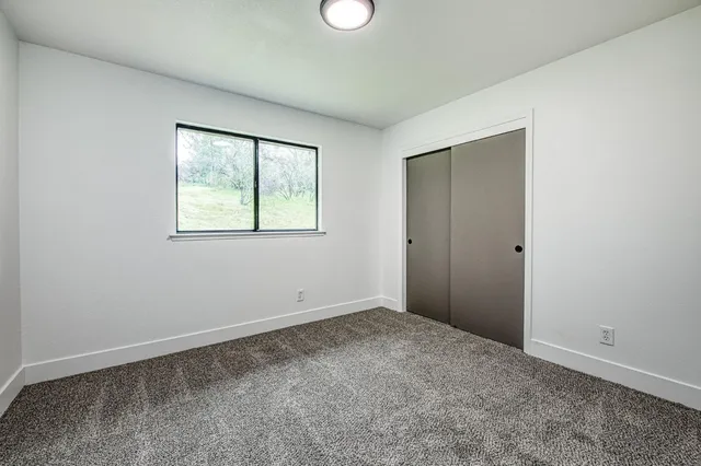 an empty room with windows and closet