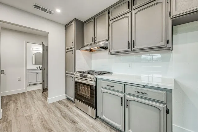 a kitchen with stainless steel appliances granite countertop a stove and a refrigerator