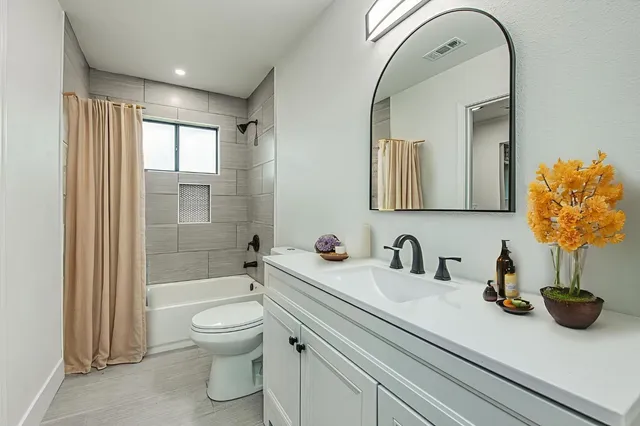 a bathroom with a toilet a sink and mirror