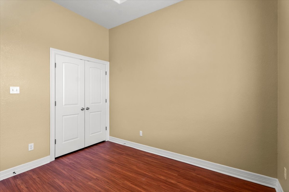 437 Balch Road Elgin, TX 78621 - Photo 19 of 37 Rich wood-toned flooring and warm-hued walls define this flexible interior space.