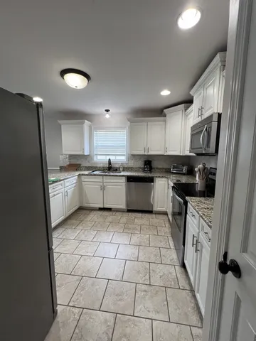 a kitchen with stainless steel appliances granite countertop a refrigerator and a stove top oven