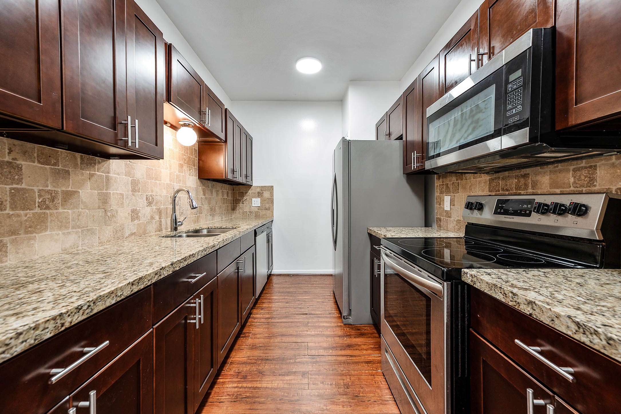6000 Reims Road, Unit 2003 Houston, TX 77036 - Photo 8 of 24 a kitchen with stainless steel appliances granite countertop a stove a sink dishwasher and microwave oven