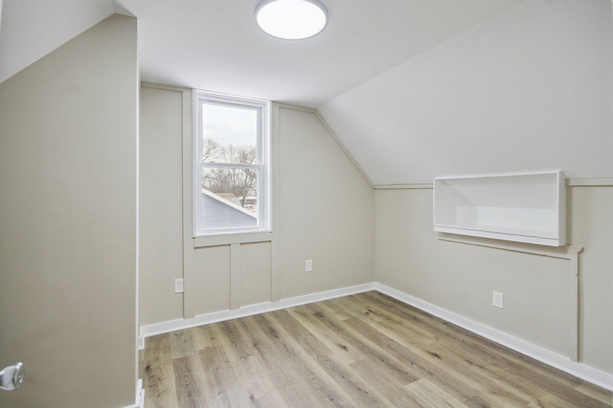 1012 Oklahoma Street Gary, IN 46403 - Photo 12 of 18 a view of an empty room with wooden floor and a window