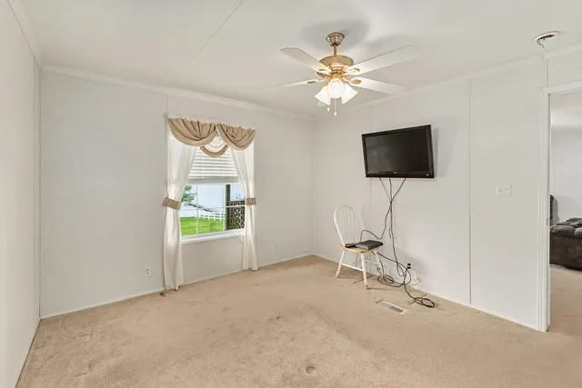 a view of a big room with windows and chandelier fan