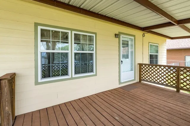 a view of a house with a large window and a tree