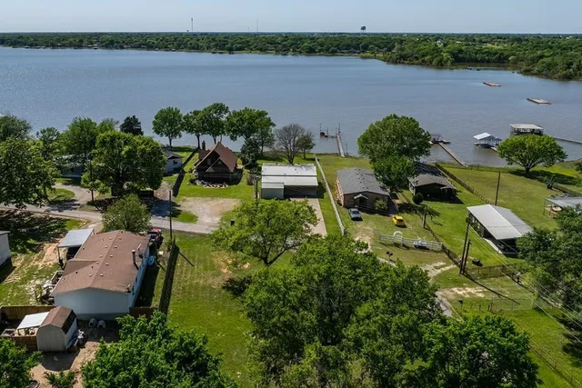 an aerial view of a house with a yard and lake view