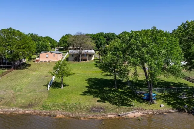 a view of a house with a big yard and palm trees