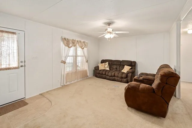 a living room with furniture and a ceiling fan