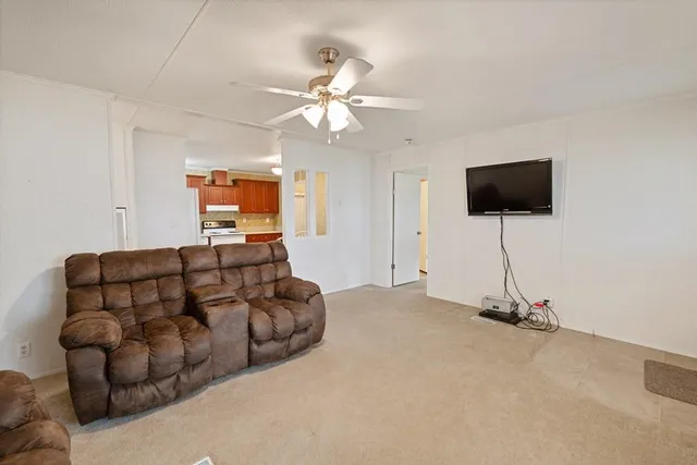 a kitchen with stainless steel appliances granite countertop a stove a refrigerator a sink a dining table and chairs with wooden floor