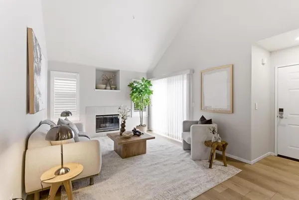 a living room with furniture a fireplace and a potted plant