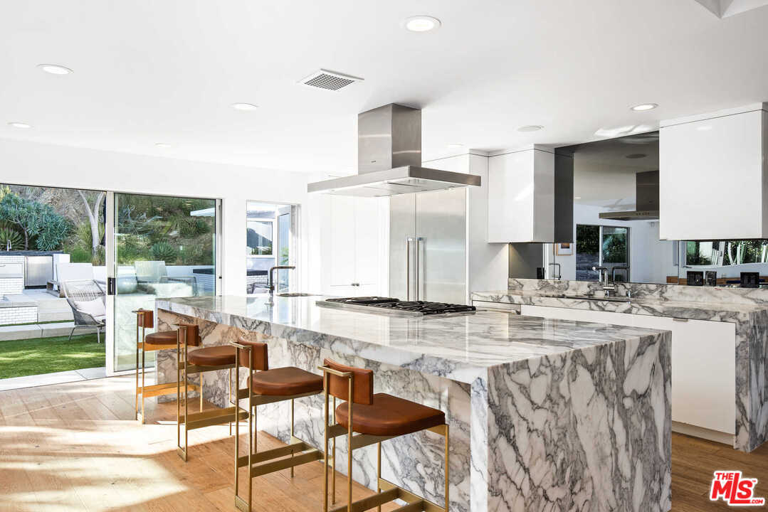 1239 Las Pulgas Road Pacific Palisades, CA 90272 - Photo 12 of 54 a view of a kitchen with kitchen island granite countertop a table and chairs in it