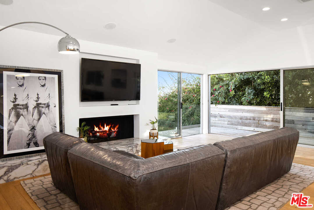 1239 Las Pulgas Road Pacific Palisades, CA 90272 - Photo 16 of 54 a living room with furniture a fireplace and a flat screen tv