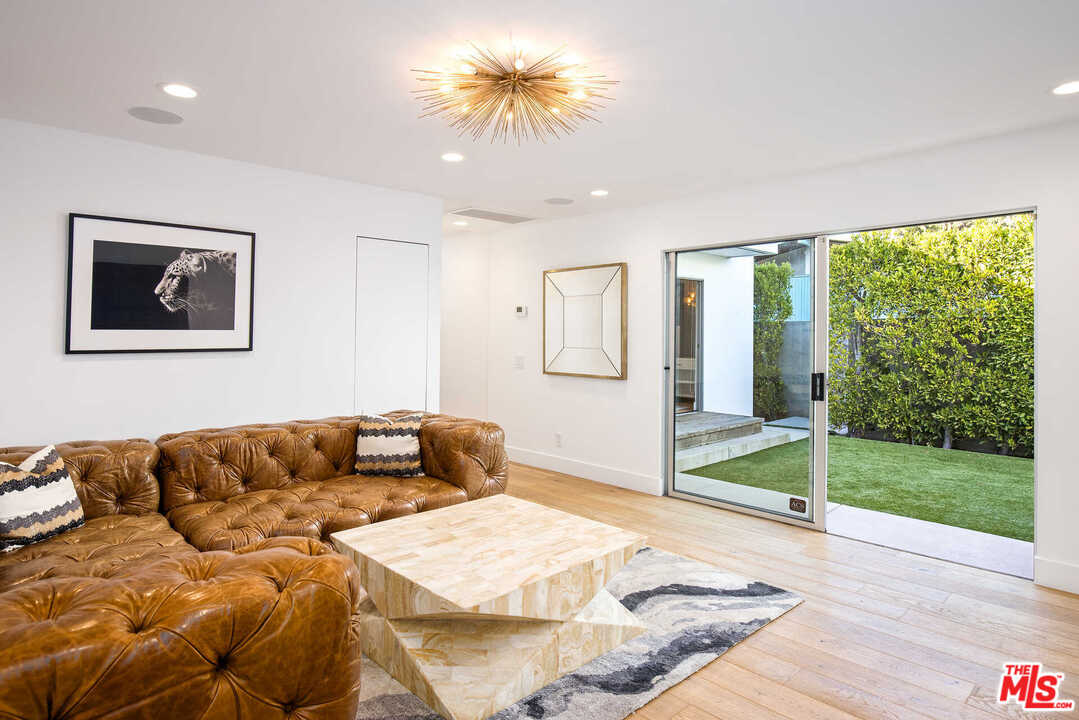 1239 Las Pulgas Road Pacific Palisades, CA 90272 - Photo 18 of 54 a living room with a couch and a floor to ceiling window