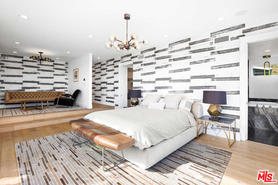1239 Las Pulgas Road Pacific Palisades, CA 90272 - Photo 24 of 54 a large room with a bed and a chandelier