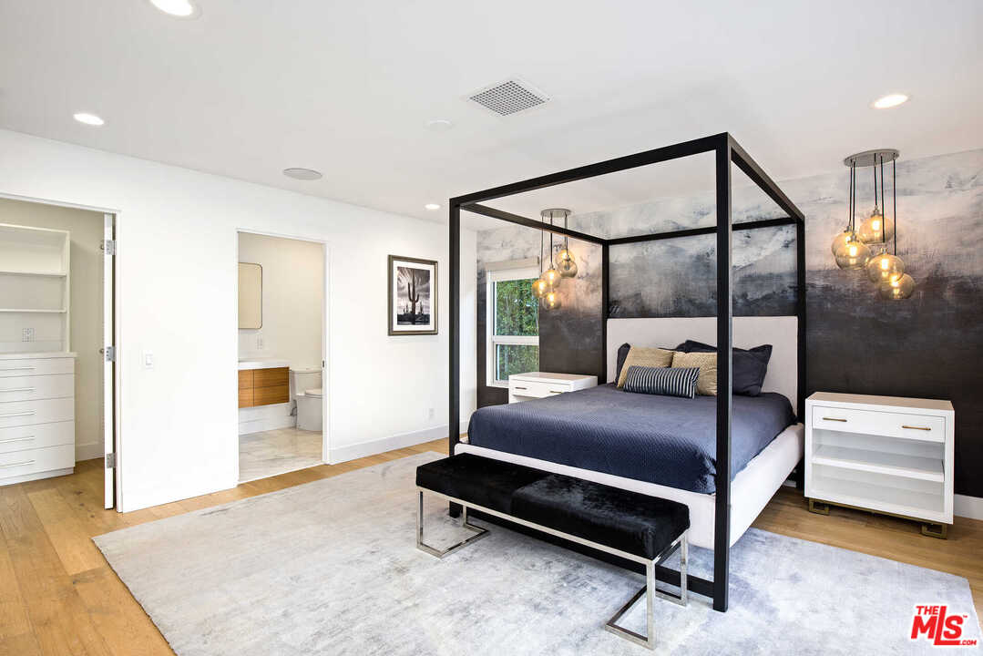 1239 Las Pulgas Road Pacific Palisades, CA 90272 - Photo 32 of 54 a bedroom with a bed window and walk in closet with wooden floor