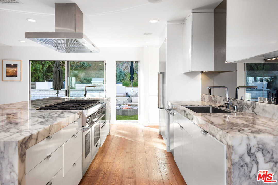 1239 Las Pulgas Road Pacific Palisades, CA 90272 - Photo 7 of 54 a kitchen with stainless steel appliances granite countertop a stove a sink and a refrigerator
