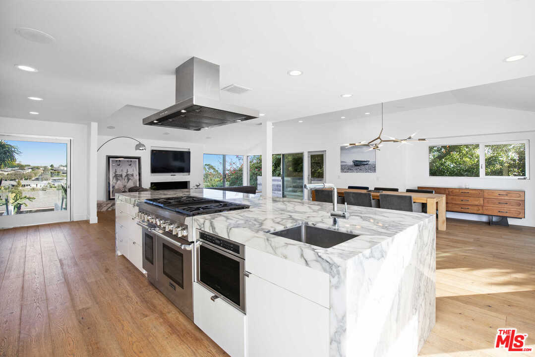 1239 Las Pulgas Road Pacific Palisades, CA 90272 - Photo 9 of 54 a kitchen with stainless steel appliances granite countertop a stove and a wooden floors