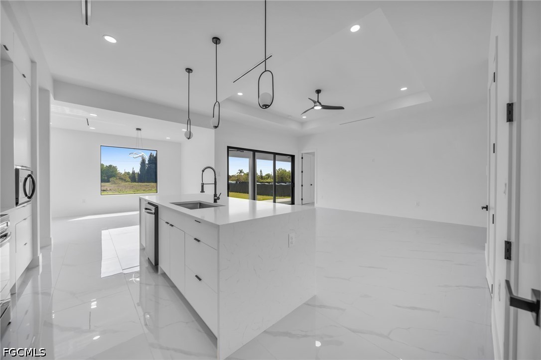 1618 Moore Avenue Lehigh Acres, FL 33972 - Photo 12 of 41 a large white kitchen with a large window a sink and stainless steel appliances