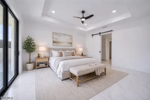 a bedroom with a large bed and a chandelier