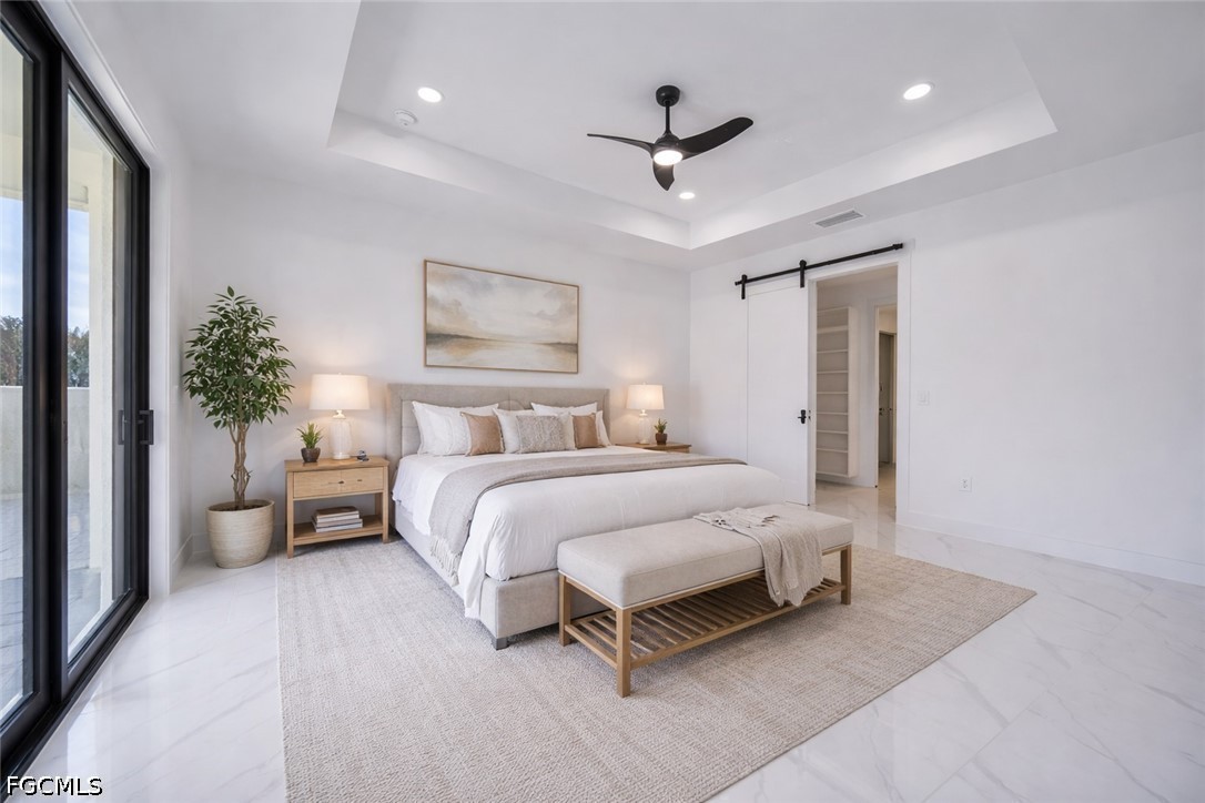 1618 Moore Avenue Lehigh Acres, FL 33972 - Photo 13 of 41 a bedroom with a large bed and a chandelier
