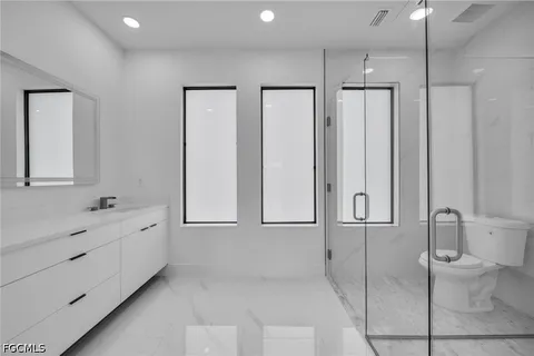 a bathroom with a toilet a sink and mirror