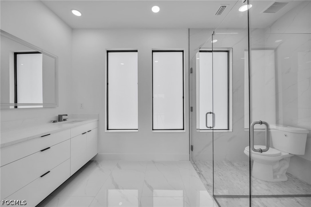 1618 Moore Avenue Lehigh Acres, FL 33972 - Photo 18 of 41 a bathroom with a toilet a sink and mirror