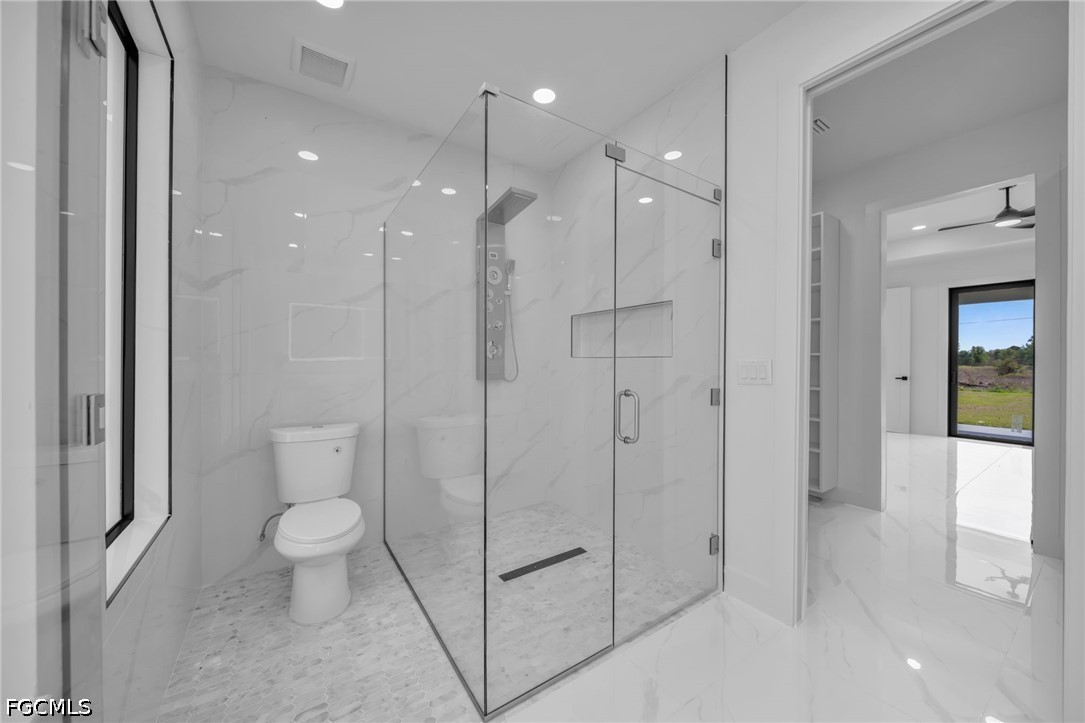 1618 Moore Avenue Lehigh Acres, FL 33972 - Photo 19 of 41 a bathroom with a shower a toilet and a sink
