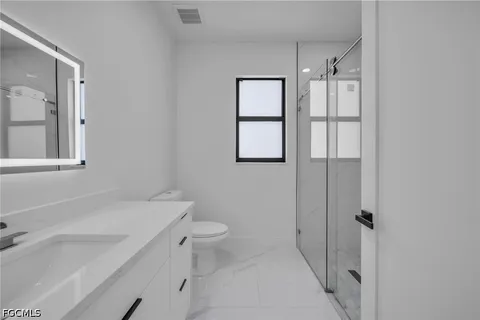 a bathroom with a sink toilet and shower
