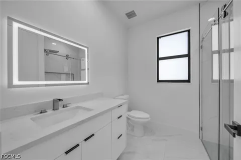 a bathroom with a sink toilet and window