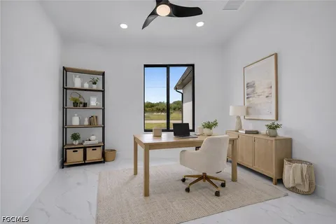 a view of a workspace with furniture and a window