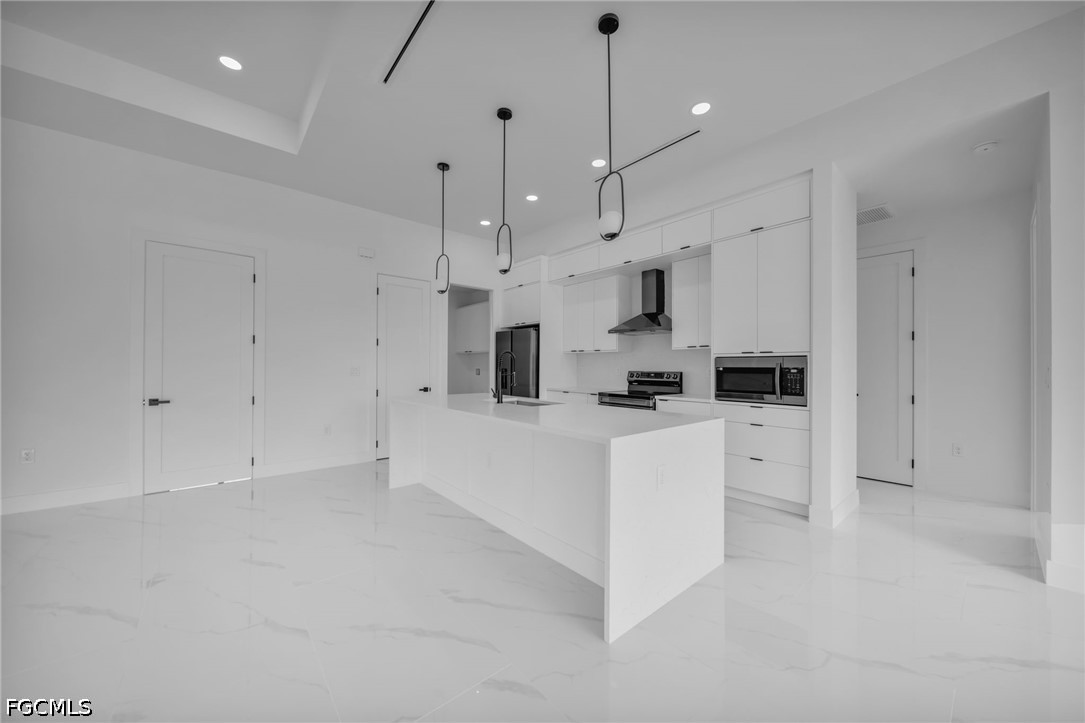 1618 Moore Avenue Lehigh Acres, FL 33972 - Photo 7 of 41 a kitchen with white cabinets and stainless steel appliances