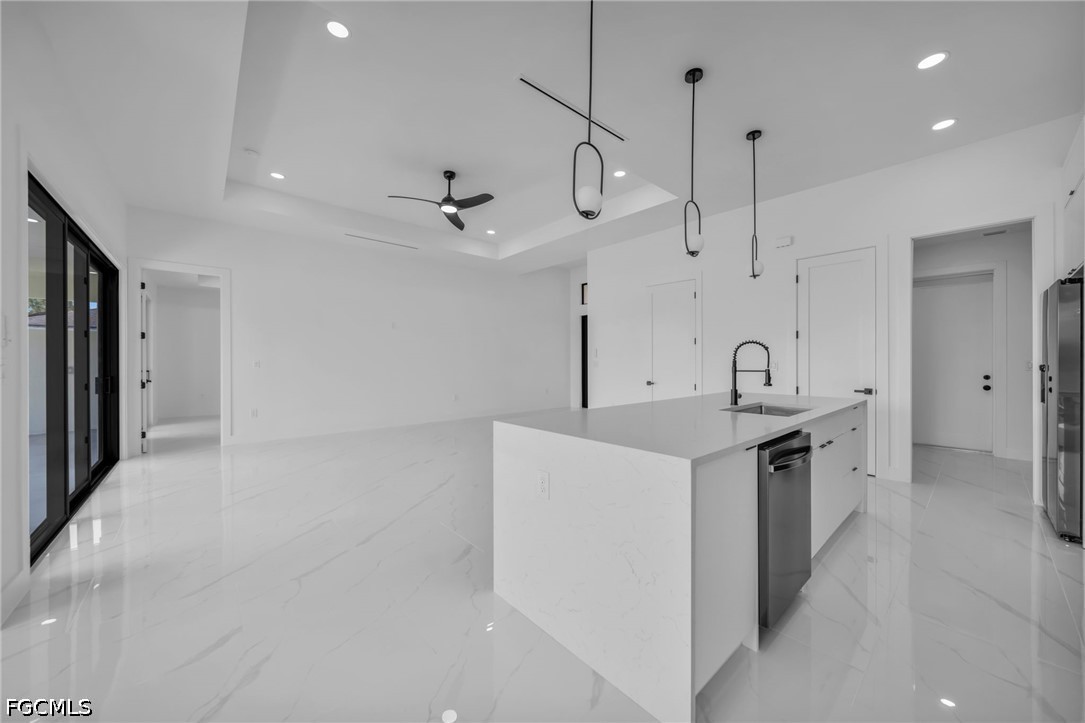1618 Moore Avenue Lehigh Acres, FL 33972 - Photo 8 of 41 a kitchen with stainless steel appliances a sink a stove a refrigerator and white cabinets