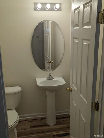 a room with wooden floor and stainless steel appliances