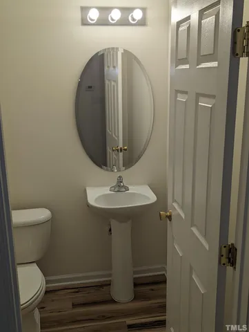a room with wooden floor and stainless steel appliances