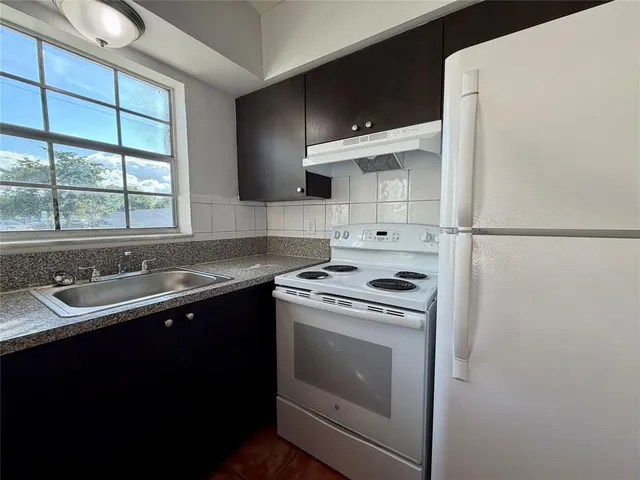 a kitchen with a sink stove and refrigerator
